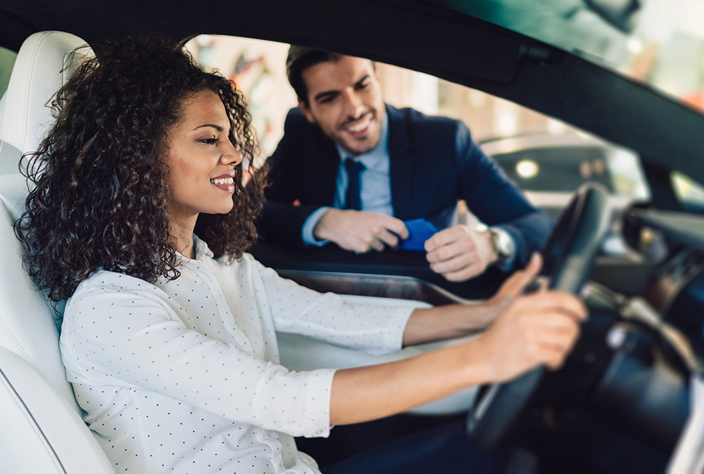 woman sitting in car at dealership